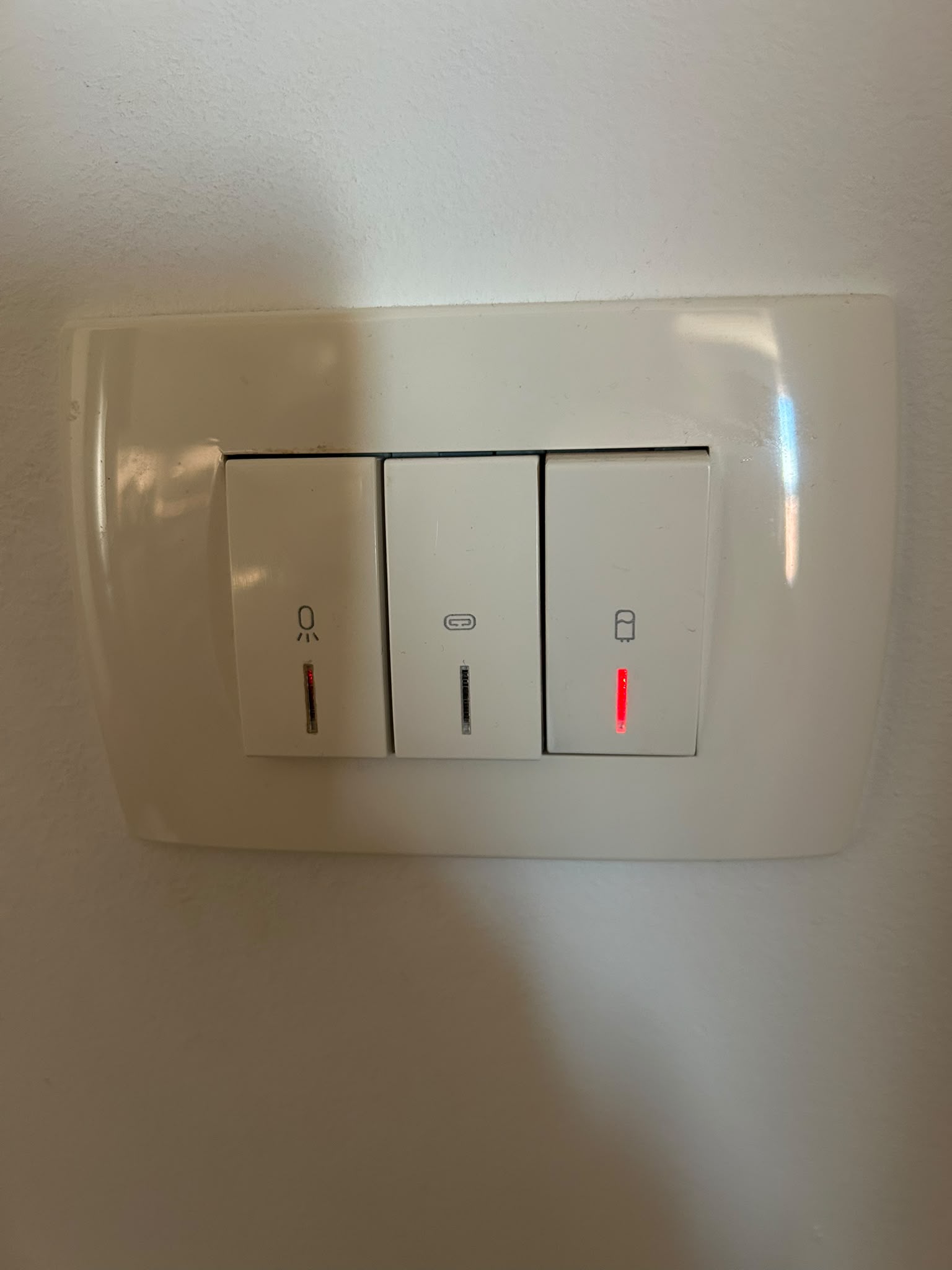 Detail spínače s ikonkou bojleru, červená kontrolka svítí